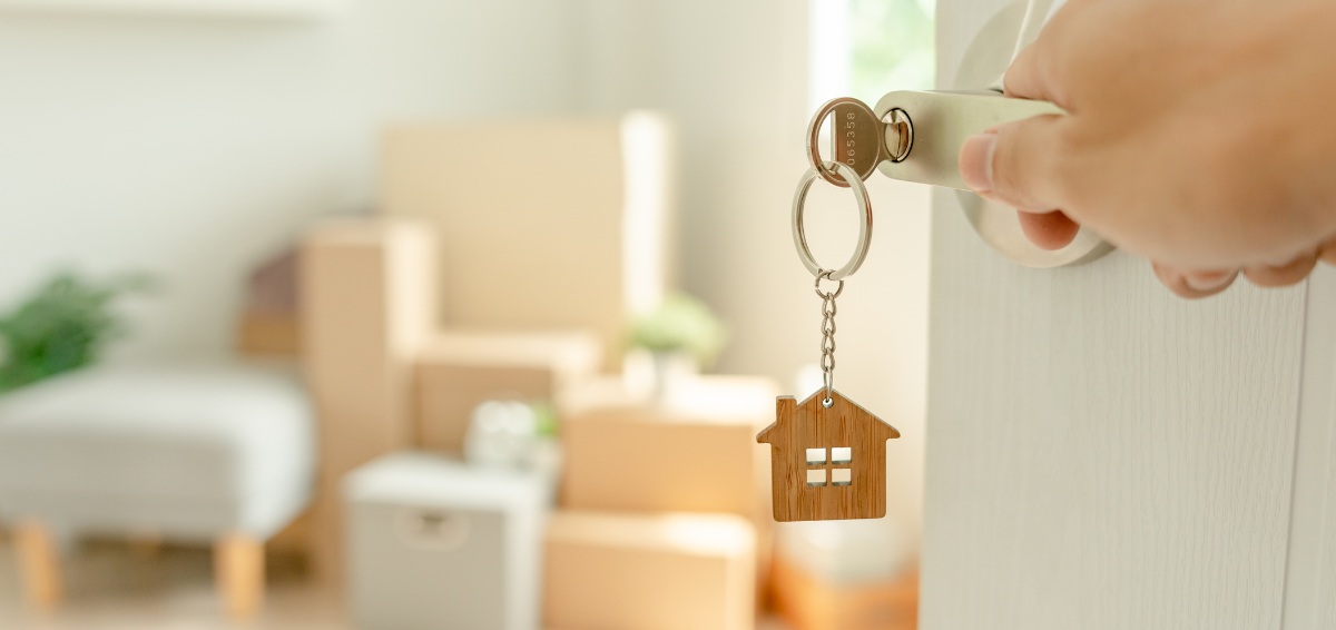 Key in a door attached to a keychain with a small wood 